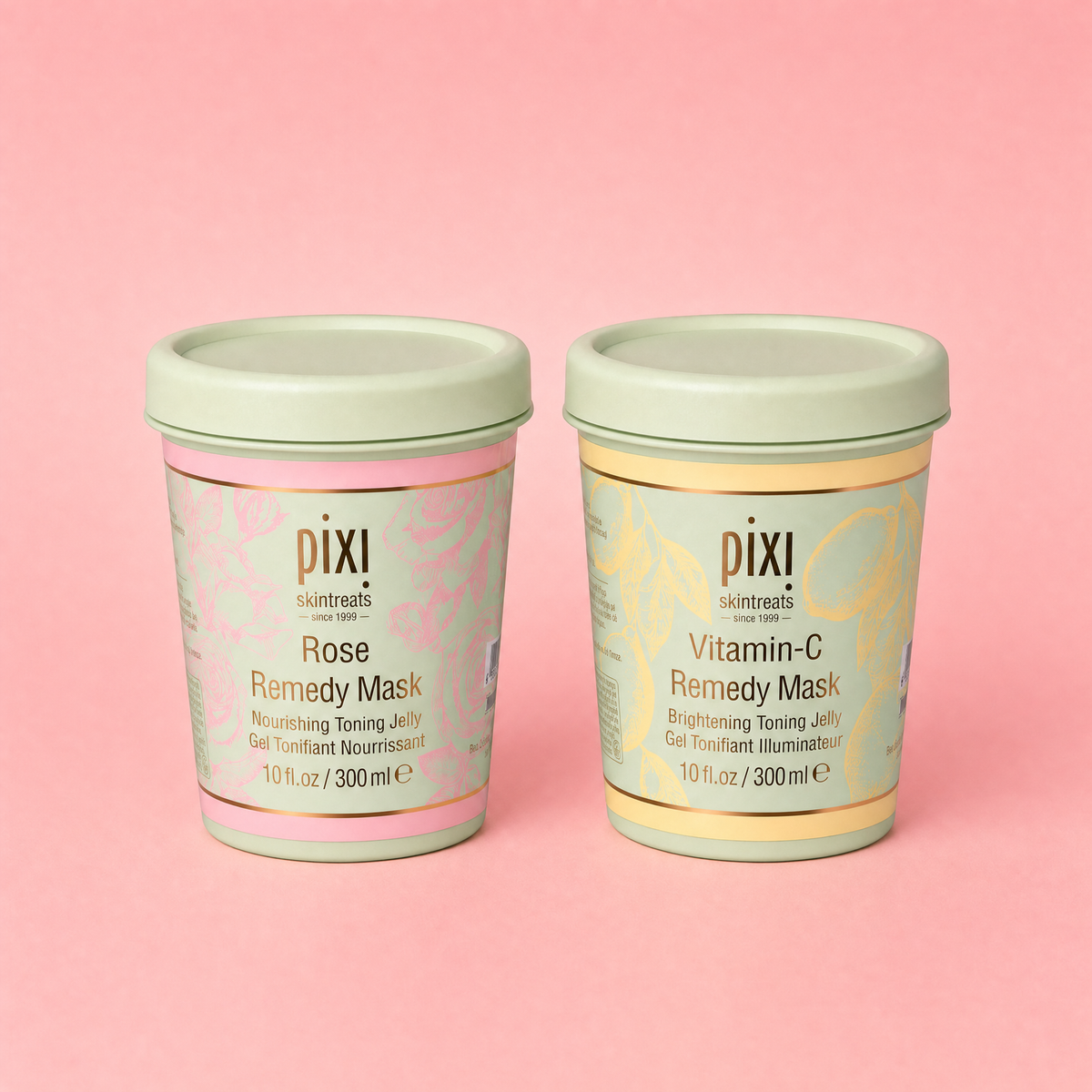 Two Pixi skincare test tube masks, 'Rose Remedy Mask' and 'Vitamin-C Remedy Mask', displayed side-by-side on a solid pink background.