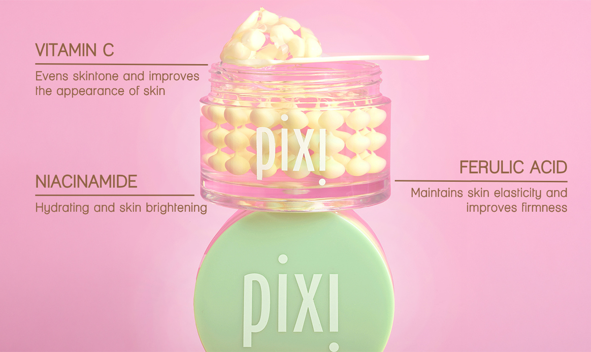 Pixi Vitamin CremeSerum jar with a mint green cap and clear jar showing yellow serum, set against a solid pink background with text detailing the ingredients.