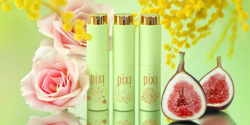 PixiPerfume trio on a green background surrounded by roses, figs, and mimosa branches