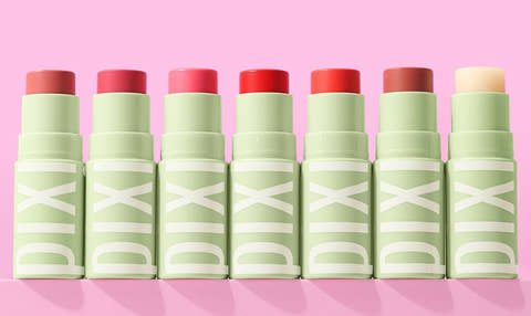 Set of +Hydra LipTreats lip balms with tinted shades on a pink background