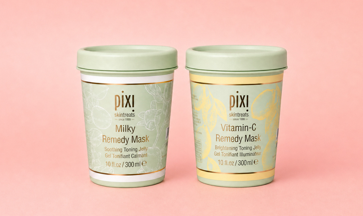Two Pixi skincare tins of Remedy Masks, one labeled Milky and one labeled Vitamin-C, set against a solid pink background.