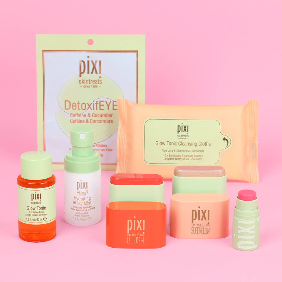 Pixi Skintreats skincare and makeup set arranged on a pink background, including DetoxifEYE pouch, cleansing wipes, toner, moisturizer, blush, superglow and a small +Hydra Liptreat product. view 1