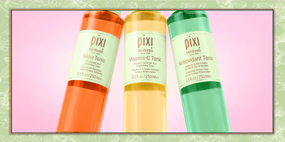 Three Pixi Skincare bottles shown together on a pink background with a decorative border: Glow Tonic in orange, Vitamin-C Tonic in yellow, and Antioxidant Tonic in green.