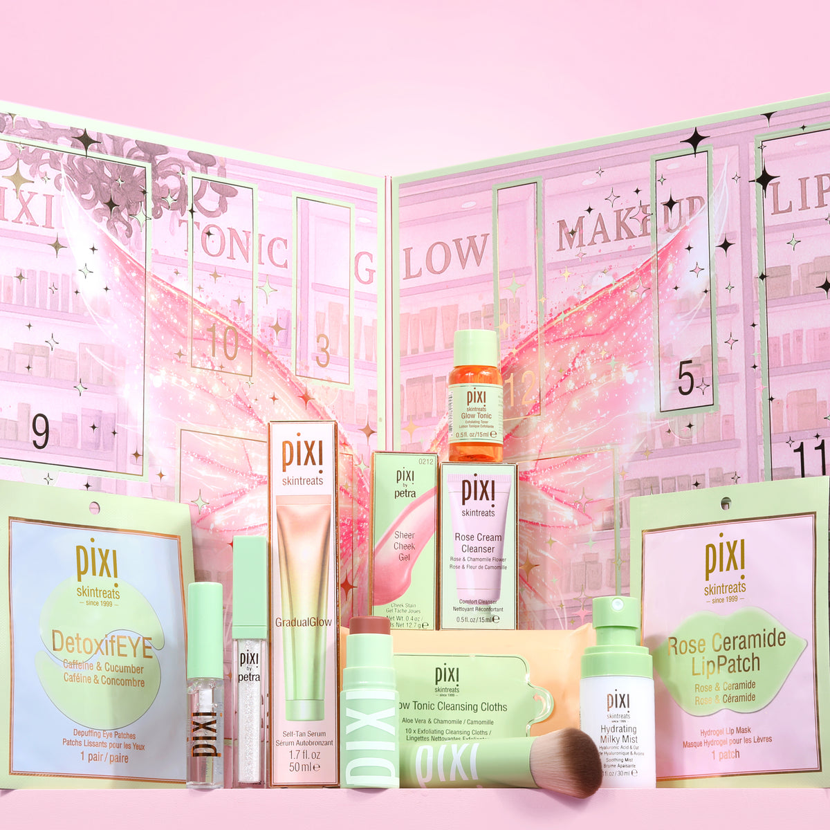 Pixi 12 Days of Discovery Beauty Advent Calendar includes makeup and skincare set arranged in front of a pink numbered advent calendar. Visible products include DetoxiEYE eyeshadow, Rose Ceramide LipPatch, Cleansing Oil, Cleansing Cream, Primer, Toner, and a makeup brush, all branded Pixi.