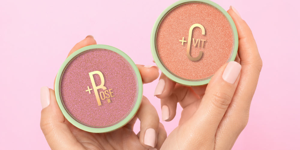 Glow-y Powder in Rose and Vitamin C shown in hand on a pink background - View 1