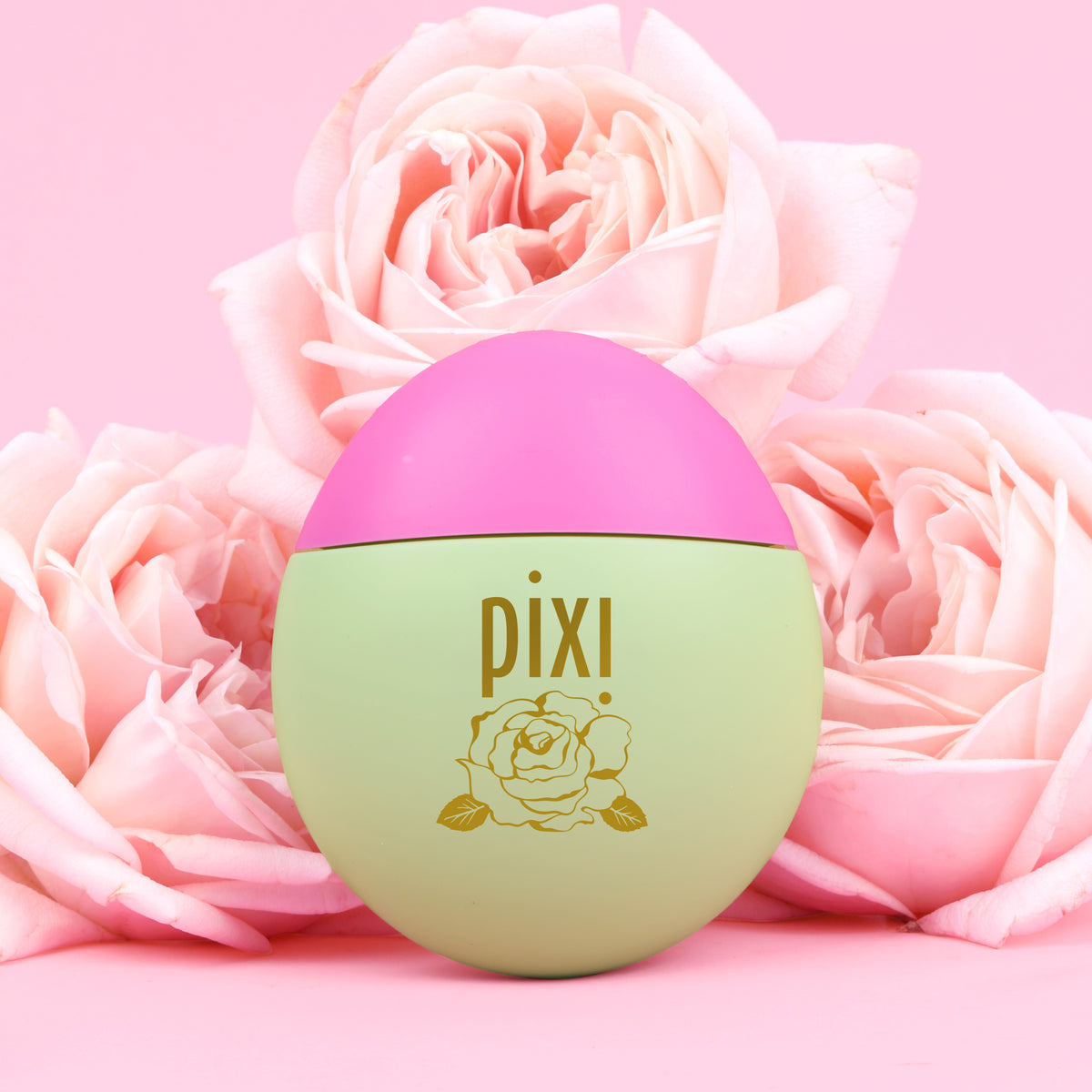 Pixi HandHero PixiRose scented product arranged among pink roses on a pink background.