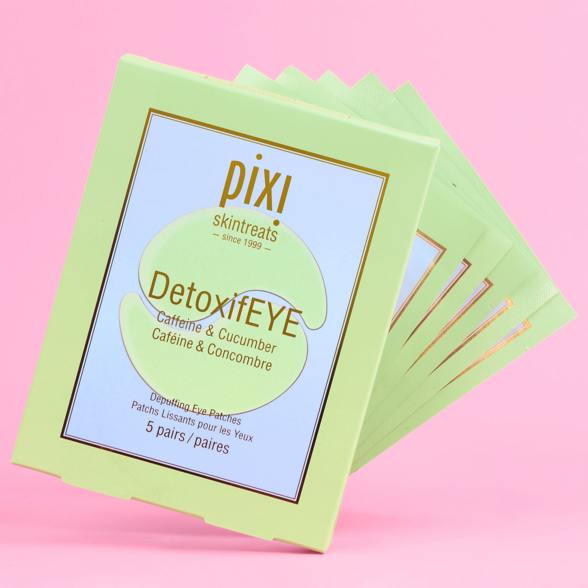 A 5 pack stack of Pixi Skintreats DetoxifEYE eye patches in a light green clamshell box, set against a solid pink background.