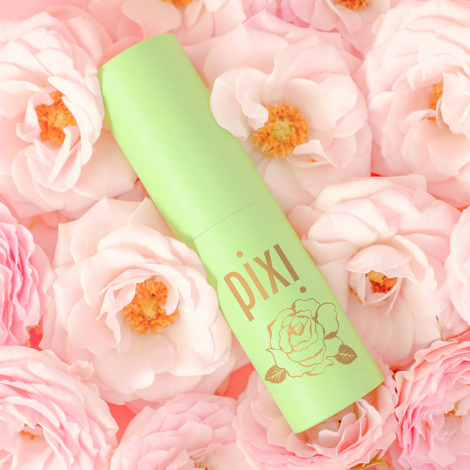 Green PIXI Rose Perfume bottle on pink flowers view 1