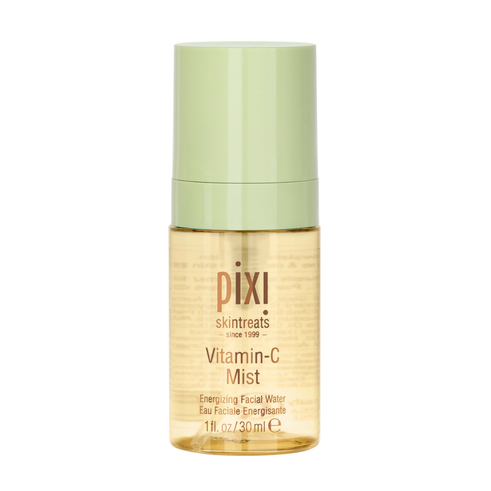 Pixi SkinTreats Vitamin-C Mist in a clear bottle showing the golden formula inside, topped with a light sage green cap, on a solid white background. view 1