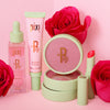 Pixi Beauty makeup products with pink roses on a pink background