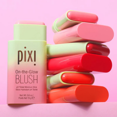 Pixi On-the-Glow Blush stick with multiple shades on a pink background